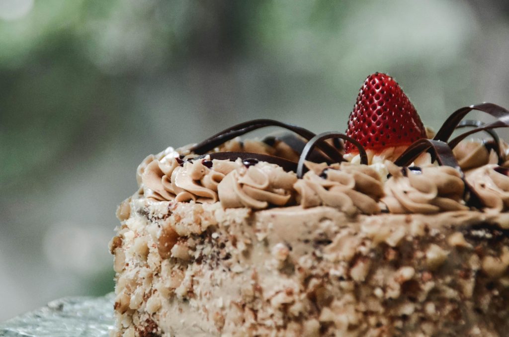 Close-up of a luxurious chocolate cake adorned with fresh strawberry and cream in Mandaue City.